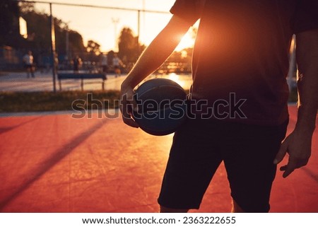 Man with basketball ball on a public court.