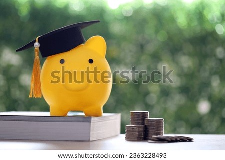 Graduation hat on piggy bank with stack of coins money on nature green background, Saving money for education concept 