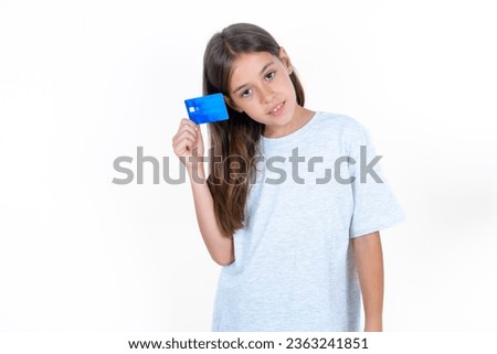 Close up photo of optimistic Beautiful kid girl wearing grey T-shirt over white background hold card