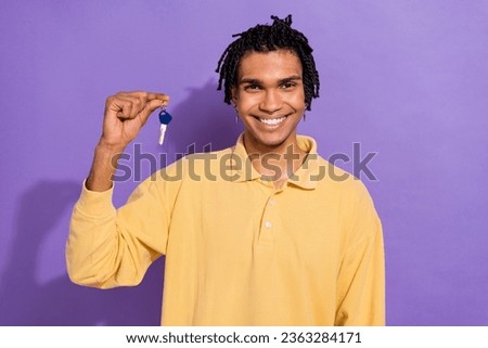 Photo of cheerful nice man wear stylish yellow clothes polo hand hold key buy new house villa cottage isolated on purple color background