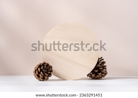 Wooden circular podium on beige background with fir cones . Concept scene stage showcase for new product, promotion sale, banner, presentation, cosmetic
