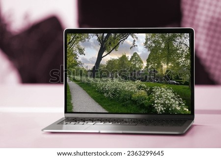 Beautiful cityscape with green grass on laptop screen