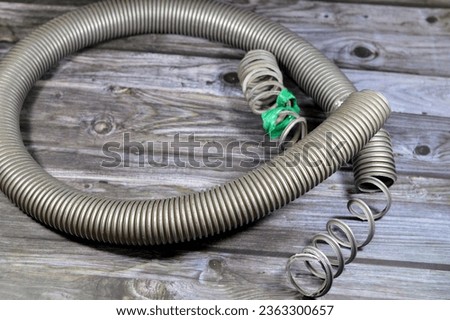 A broken flexible hose from a vacuum cleaner, substandard materials and maintenance services concept, a vacuum cleaner is an electrical house machine that collects dust and dirt by suction pressure Royalty-Free Stock Photo #2363300657