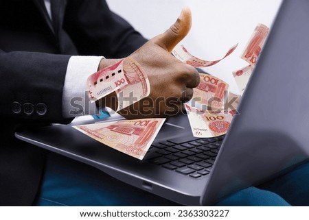 100 Chinese Yuan notes coming out of laptop with Business man giving thumbs up, Financial concept. Make money on the Internet, working with a laptop