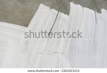 Photo of the wall surface texture with white grunge paint brush strokes.