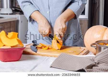 Senior Caucasian woman peeling pumpkin in home kitchen