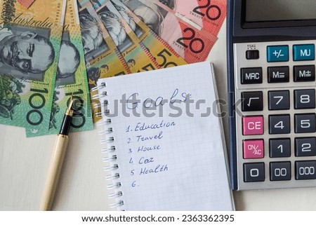 Note pad with Australian money, AUD on desk. Shopping or goal concept