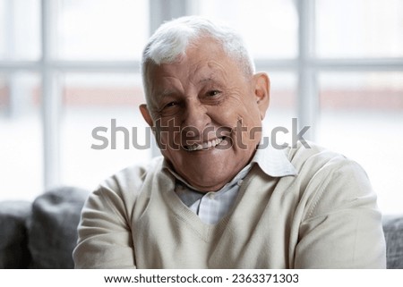 Close up headshot portrait of smiling elderly 70s man speak talk on video call with relatives, happy mature 80s grandfather look at camera have pleasant webcam conference conversation at home
