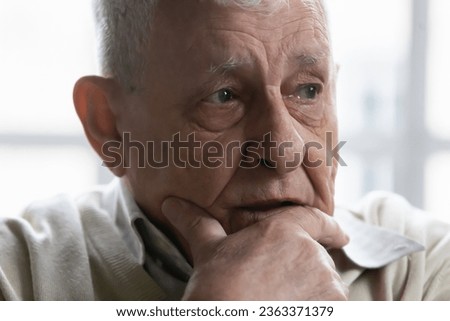 Close up of upset mature 80s man feel lonely look in distance mourning or yearning, sad pensive elderly 70s grandfather thinking pondering, distressed with solitude loneliness in retirement house Royalty-Free Stock Photo #2363371379