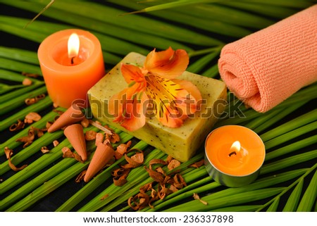 Spa set with towel, candle, soap ,orange orchid on palm leaf