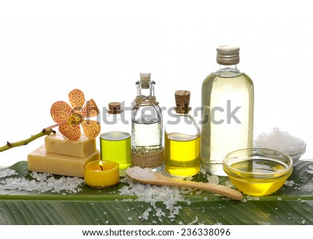 spa supplies with orchid, oil, yellow candle ,soap salt on banana leaf