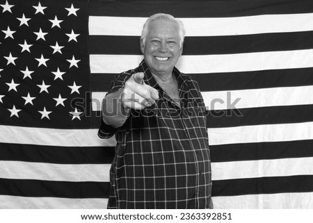 Photo Booth. American Flag. A proud American Man Salutes and Poses in front of the American Flag while waiting for his pictures to be taken while in a photo booth at a Fourth of July Party. America. 