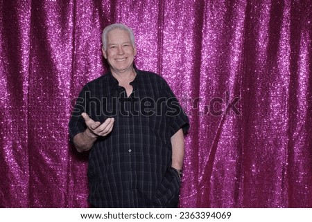 Photo Booth. A man smiles as he waits for his pictures to be taken while enjoying a Photo Booth at a Wedding or Party. People love Photo Booths and get pictures printed while they wait. Always Fun.