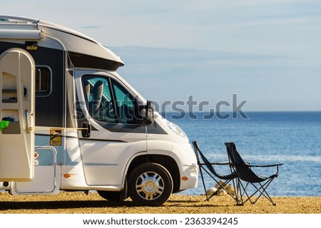 Caravan with camp chairs on mediterranean coast, Spain. Wild camping on beach. Holidays and traveling in motorhome. Royalty-Free Stock Photo #2363394245