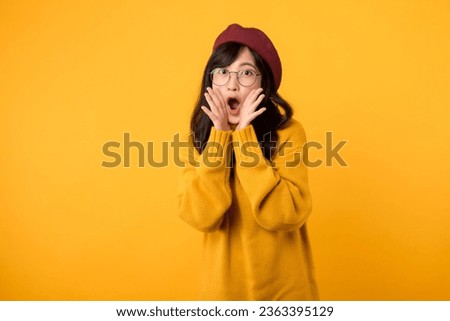 Wow. Young emotional surprised asian woman standing with open mouth. Beautiful female half-length front portrait isolated on yellow studio background. Human emotions, facial expression concept.