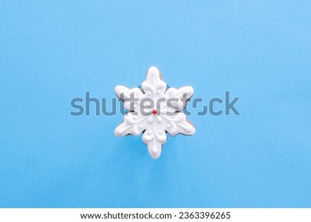 Gingerbread in the shape of a snowflake on a blue background.
