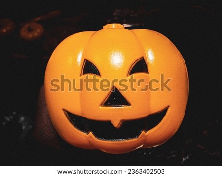 Orange pumpkin accessories with scary face in black background.