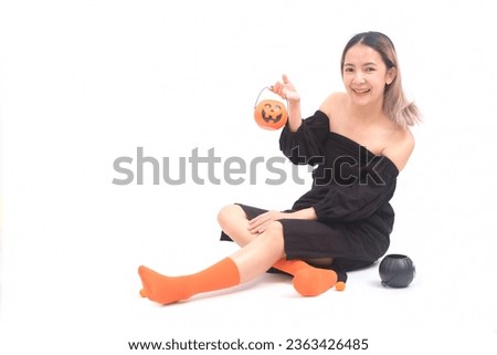 A young woman dressed in a Halloween costume holiday holding a Jack O'lantern pumpkin on her hands for your test or advertisement with white background with. The concept of celebrating.