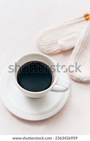 A cup of black coffee in a white coffee cup with cream and musta