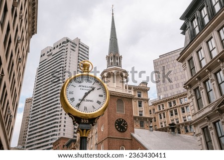 Boston, MA, US-June 30, 2023: Old fashioned clock reading Jewelers Exchange on street in downtown area surrounded by skyscrapers and historical buildings.