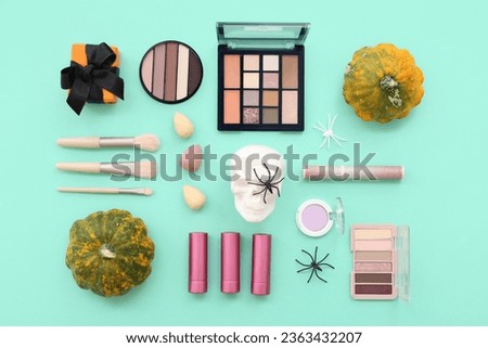 Makeup products, gift box and squashes for Halloween celebration on turquoise background