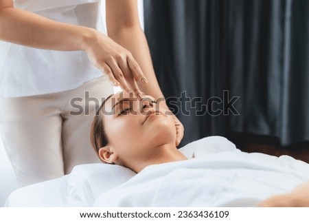 Caucasian woman enjoying relaxing anti-stress head massage and pampering facial beauty skin recreation leisure in dayspa modern light ambient at luxury resort or hotel spa salon. Quiescent Royalty-Free Stock Photo #2363436109