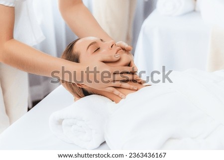 Caucasian woman enjoying relaxing anti-stress head massage and pampering facial beauty skin recreation leisure in dayspa modern light ambient at luxury resort or hotel spa salon. Quiescent Royalty-Free Stock Photo #2363436167