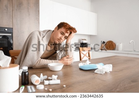 Ill young man in kitchen