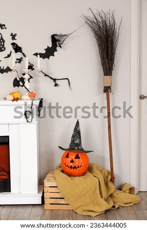 Halloween pumpkin with witch hat on box in living room