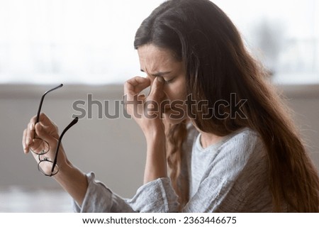 Close up exhausted woman massaging eyelids, taking off glasses, tired freelancer or student suffering from eyestrain or dry eye syndrome, feeling dizziness or headache after long hours work Royalty-Free Stock Photo #2363446675
