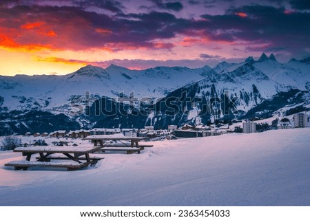 Cozy resting place with great view at sunrise. Famous ski resort view from the slope at dawn, La Toussuire, France, Europe Royalty-Free Stock Photo #2363454033