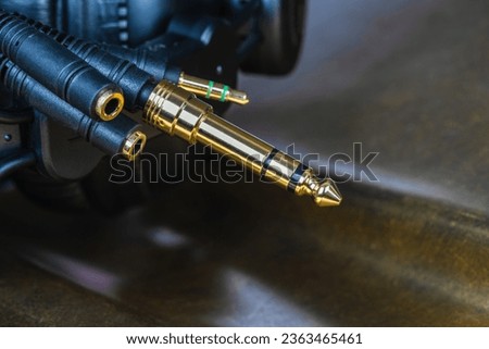 Audio jack connectors on a dark metalic surface, close up view