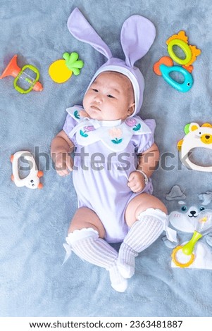 Baby boy in bunny costume,Cute baby Easter bunny. Little baby boy with bunny ears and Easter eggs in wicker basket in white fur. Symbol of Easter holiday, birth, spring, religion.