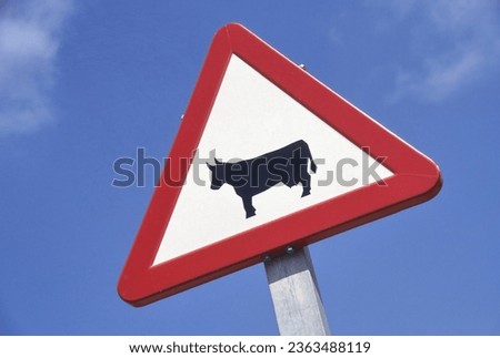 Traffic sign that is warning for domestic animals such as cows on the road