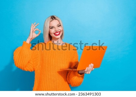 Portrait of good mood nice woman with bob hairdo dressed knitwear sweater hold laptop showing okey isolated on blue color background