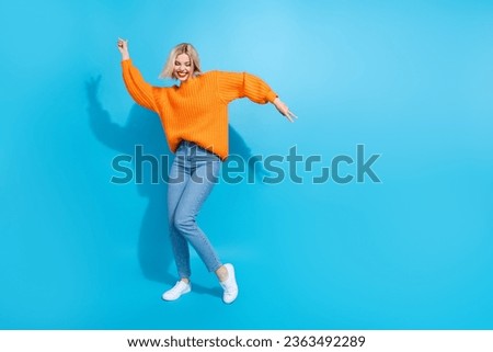 Full length photo of overjoyed cute girlish woman dressed knitwear sweater jeans dancing show v-sign isolated on blue color background