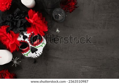 Honor the rich tradition of mexican Day of the Dead. Top view flat lay of traditional mask, candles, carnations, spooky insects on texture grey background with commercial placeholder