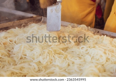 Person grilling white onion on a griddle