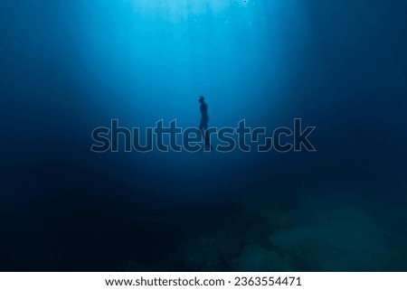Freediver Swimming in Deep Sea With Sunrays. Young Man DIver Eploring Sea Life. Royalty-Free Stock Photo #2363554471