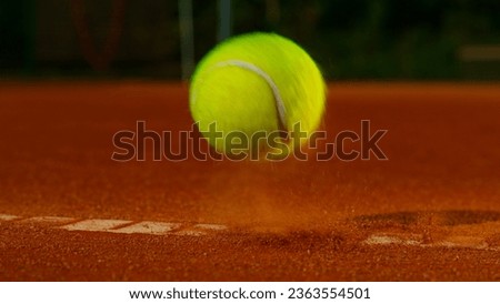 Bouncing tennis ball on clay court, freeze motion Royalty-Free Stock Photo #2363554501