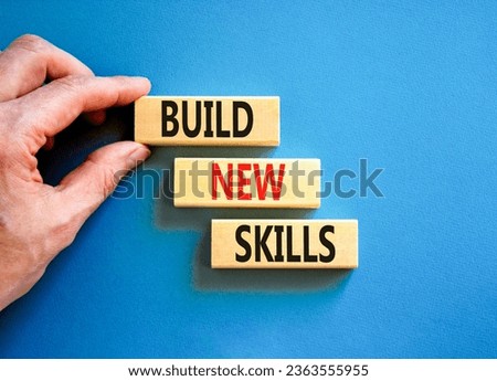 Build new skills symbol. Concept word Build new skills on beautiful wooden block. Businessman hand. Beautiful blue table blue background. Business, education build new skills concept. Copy space.