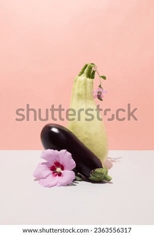 Still life with eggplant, zucchini and flowers. Creative egetable concept on gradient background Royalty-Free Stock Photo #2363556317