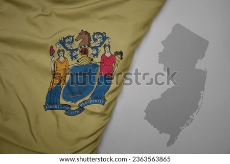big waving national colorful flag and map of new jersey state on the gray background. macro