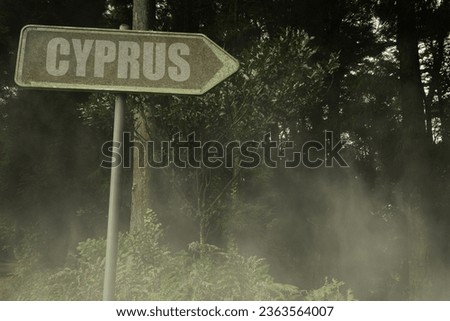 vintage old signboard with text cyprus near the green sinister forest