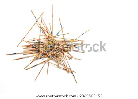 Mikado game on white, wooden pick-up sticks should be taken without moving the others, metaphor in business to solve one problem after another without endangering the whole, copy space, selected focus Royalty-Free Stock Photo #2363565155