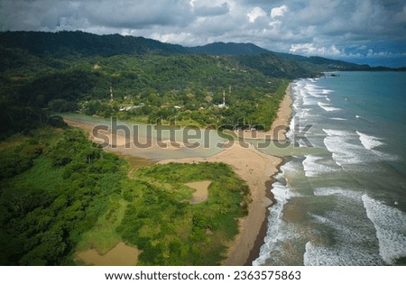 Aerial view of a tropical village in Costa Rica. Palms, river, sea and town. 
