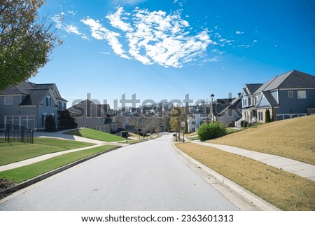 Large and quiet residential street in downhill upscale neighborhood with two and three story new development suburban single family home suburbs of Atlanta, Georgia, USA. Subdivision HOA area Royalty-Free Stock Photo #2363601313