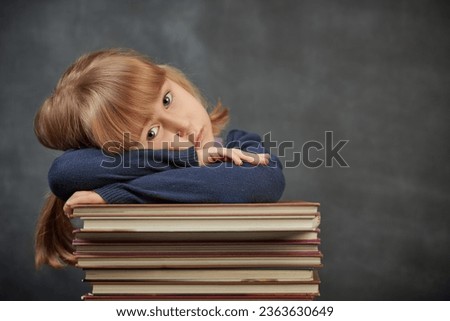 Back to school. Portrait of a little schoolgirl in class. Background with black school board and place for text. Education.