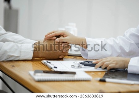 Kind doctor offering a loving gesture to a sick person during a health crisis. Support, trust and hospital care with a doctor and patient holding hands, sharing bad news of a cancer diagnosis. Royalty-Free Stock Photo #2363633819