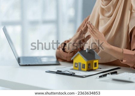 Muslim businesswoman home brokerage builds the company's confidence with clients to rent, buy, mortgage, loan or insure homes within the office.